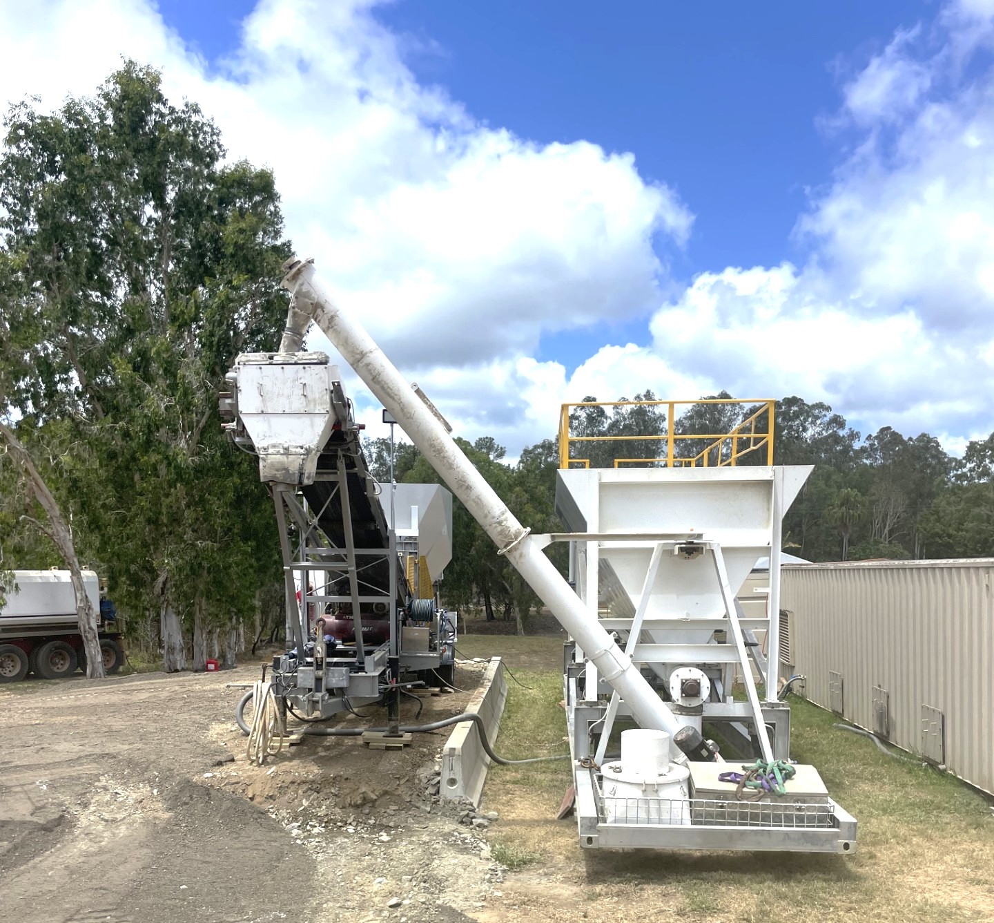 A concrete batching plant in operation, blending raw materials to create ready-mix concrete.