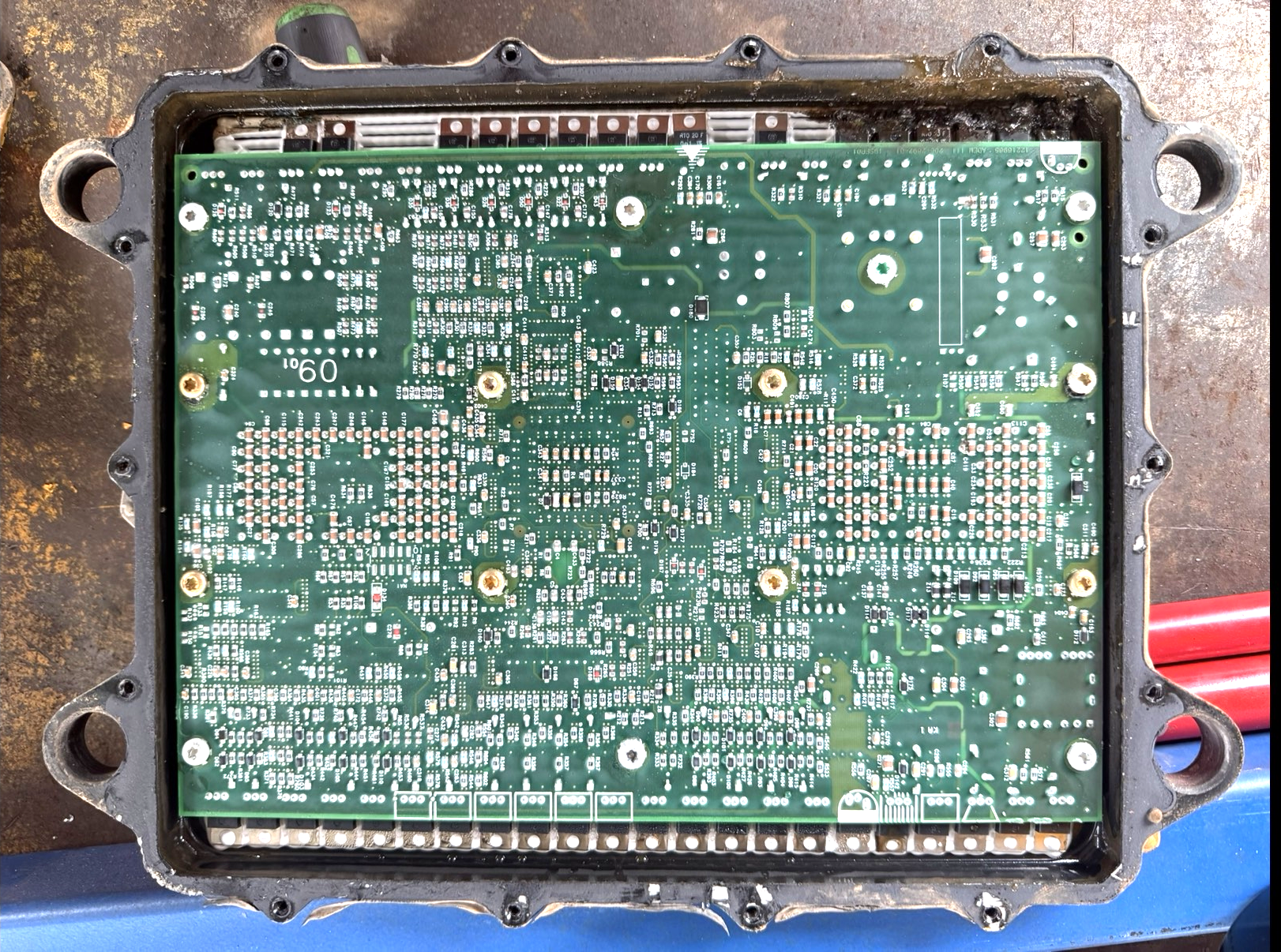 Open ECU showing internal circuit board during remapping and repair process.